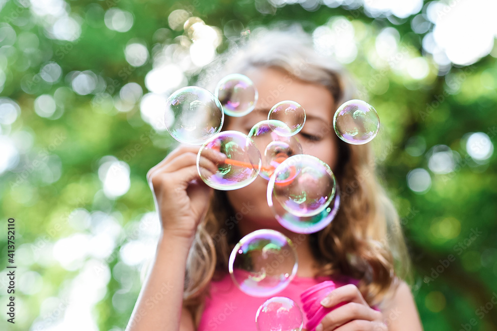 Low angle view of girl blowing bubbles at park Low angle view of girl blowing bubbles at park