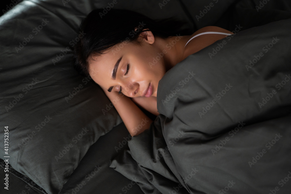 Beautiful young woman lying in bed comfortably and blissfully Beautiful young woman lying in bed comfortably and blissfully