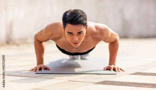 Fitness asian young handsome man doing push ups exercise