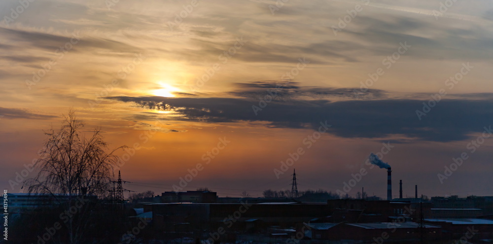 Fototapeta premium Sunset over the industrial area of the city in winter