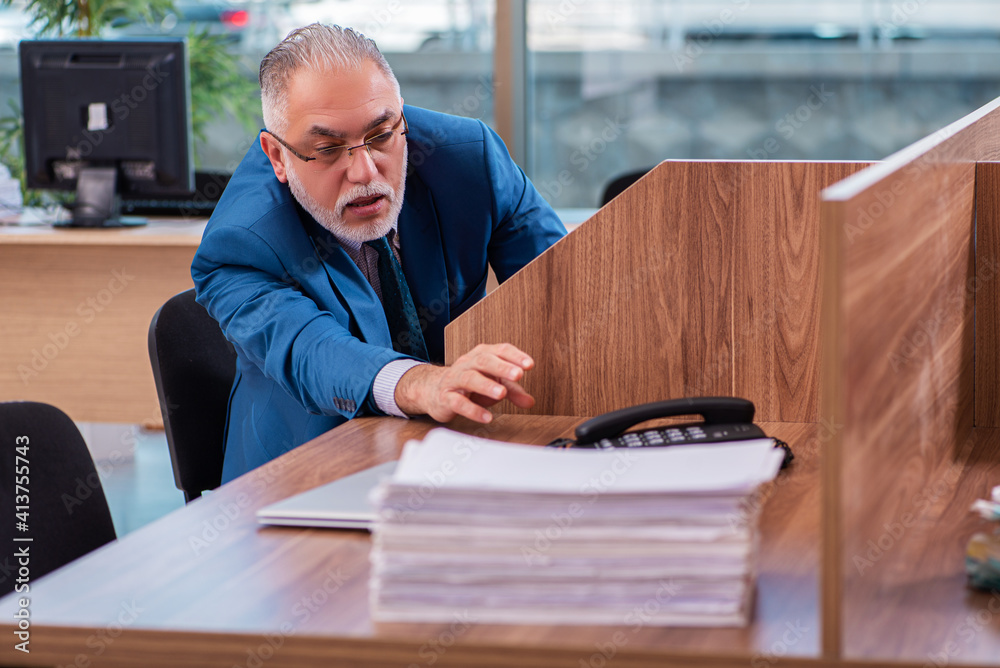 Old male employee working in the office Old male employee working in the office