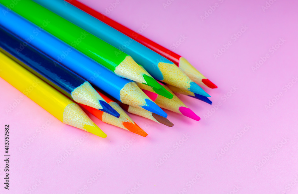 Color pencils lying on pink background. Close up. Back to school concept. Colorful art studying and painting process. Drawing with pencils. Copy space place for postcard wish. Color pencils lying on pink background. Close up. Back to school concept. Colorful art studying and painting process. Drawing with pencils. Copy space place for postcard wish.