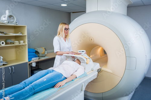 Radiologist prepares the young woman for an MRI brain examination