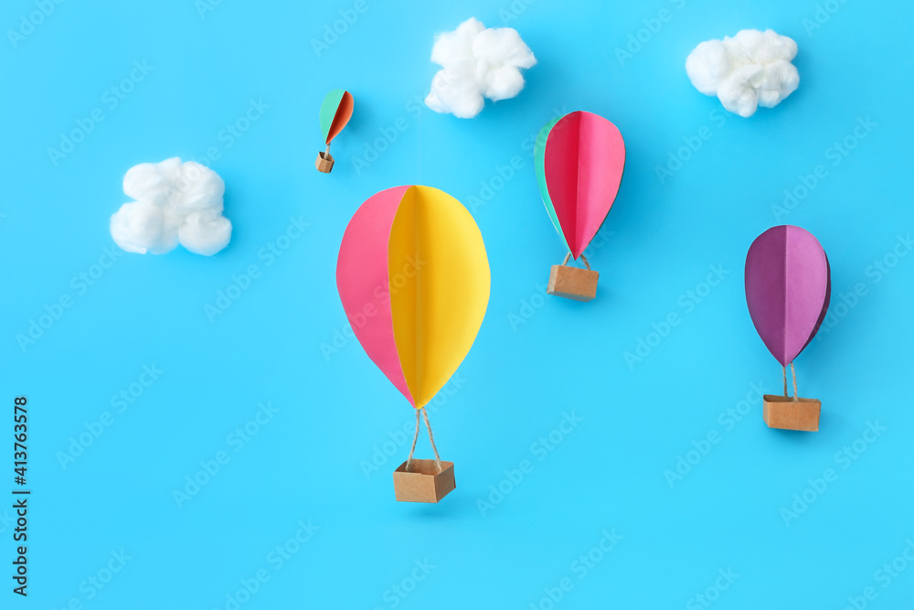 Paper hot air balloons on color background