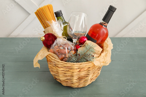 Gift basket with products and Christmas decor on table photo