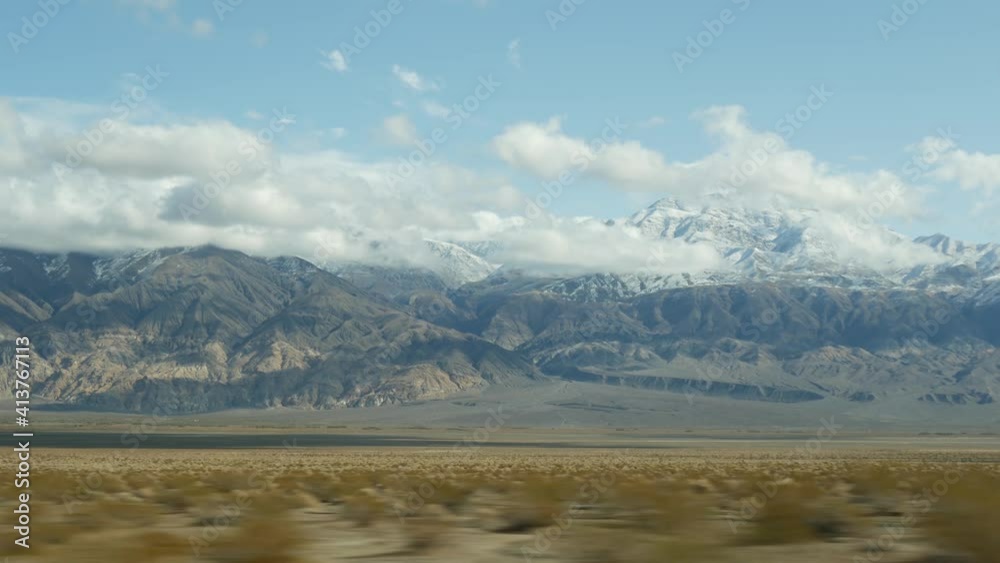 Road trip to Death Valley, driving auto in California, USA. Hitchhiking traveling in America. Highway, mountains and dry desert, arid climate wilderness. Passenger POV from car. Journey to Nevada. Road trip to Death Valley, driving auto in California, USA. Hitchhiking traveling in America. Highway, mountains and dry desert, arid climate wilderness. Passenger POV from car. Journey to Nevada.