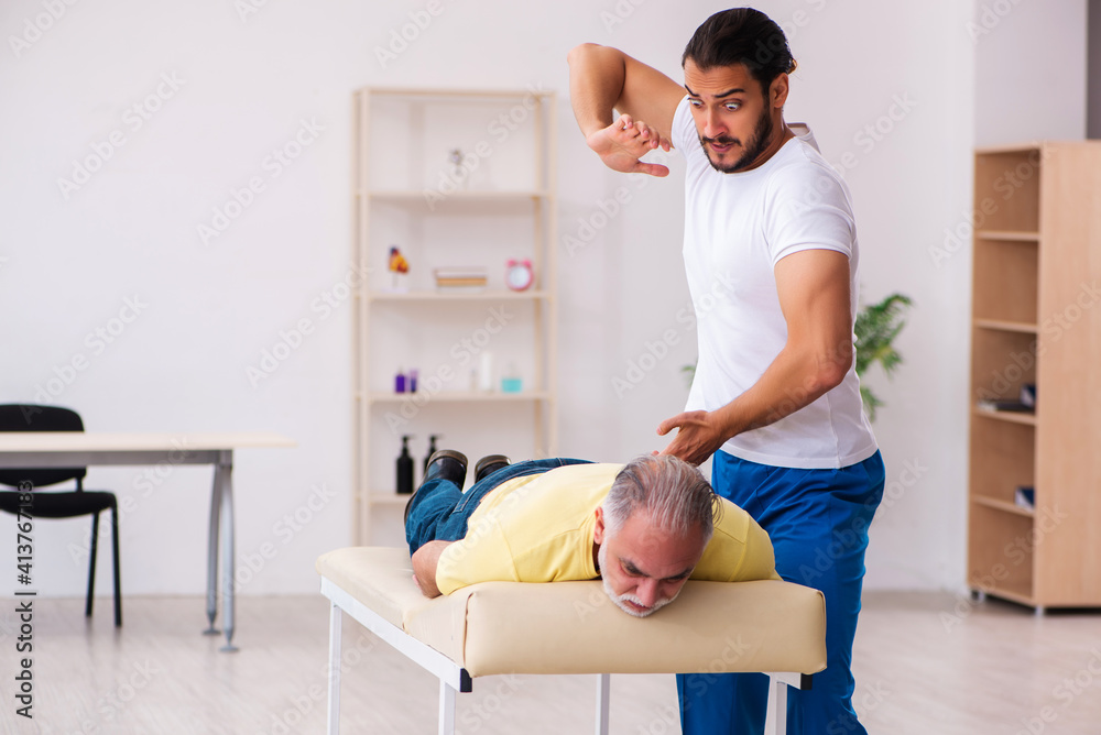 Old male patient visiting young male doctor chiropractor