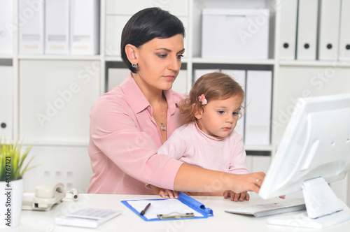 Portrait of businesswoman with her child working in office