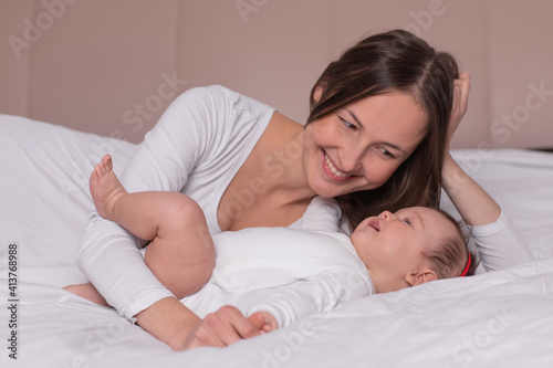 happy woman with baby lying on the bed