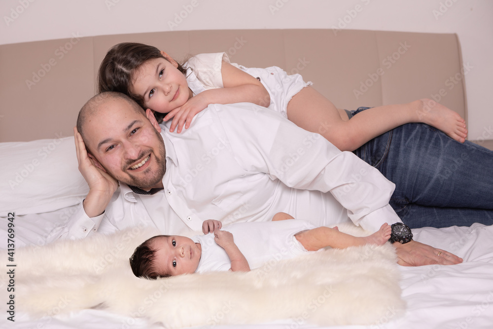 Young father with children on the bed