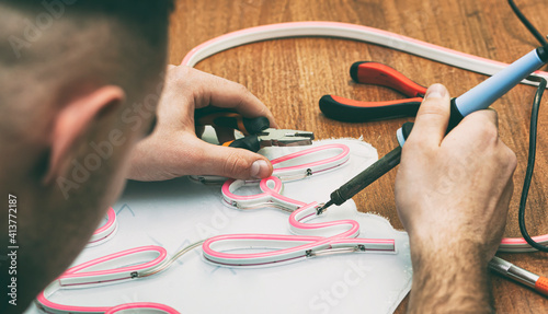 Fotografie The worker is production the sign made from the led neon ribbon