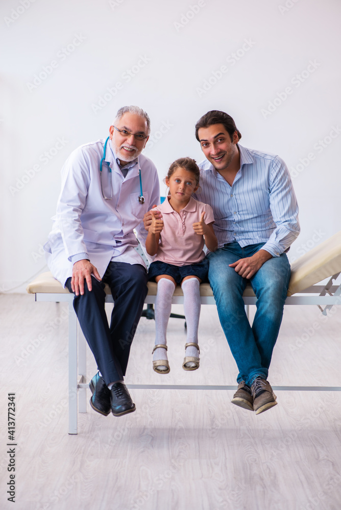 Small girl with her father visiting old male doctor Small girl with her father visiting old male doctor