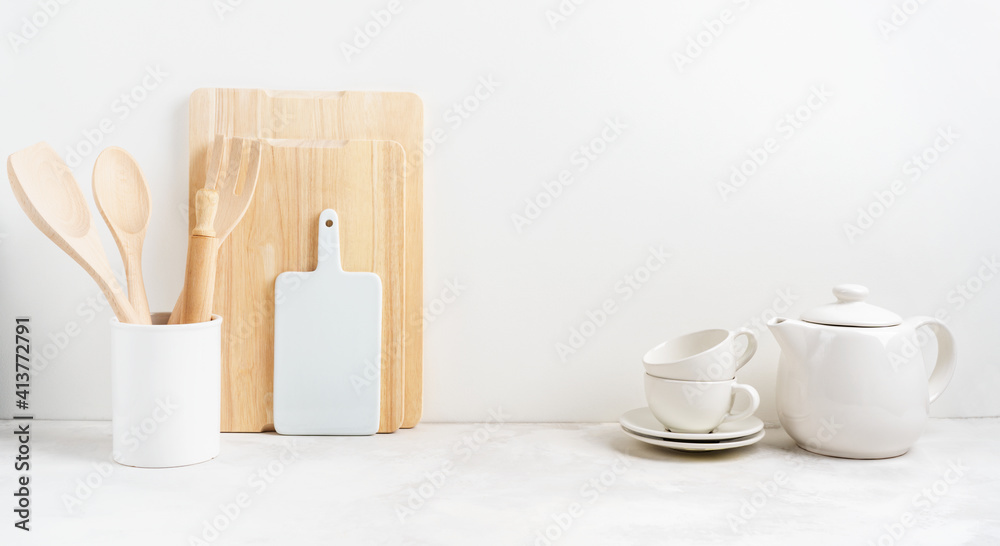 Kitchen background mockup with teepot and cooking, baking utensils rolling pin, cutboard, bowls on the table on white background. Blank space for a text, home kitchen decor concept. Wide banner.