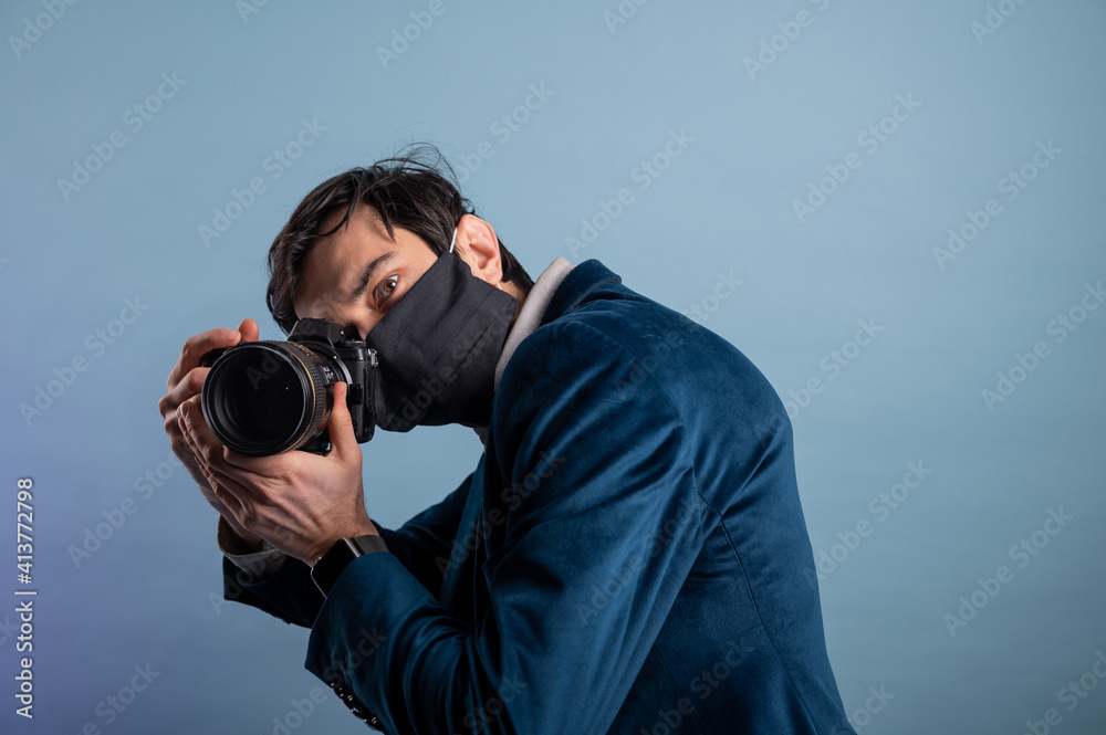Portrait of positive photographer, man with medical mask holding professional digital dslr camera Portrait of positive photographer, man with medical mask holding professional digital dslr camera