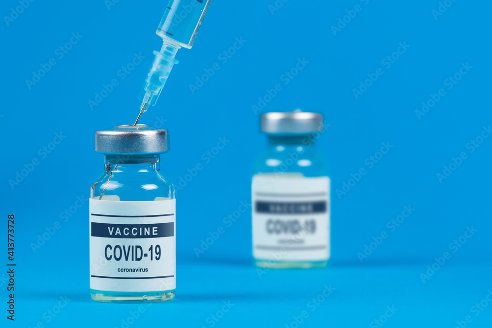 Vaccination. Syringe and vaccine COVID-19. Coronavirus on blue background Vaccination. Syringe and vaccine COVID-19. Coronavirus on blue background