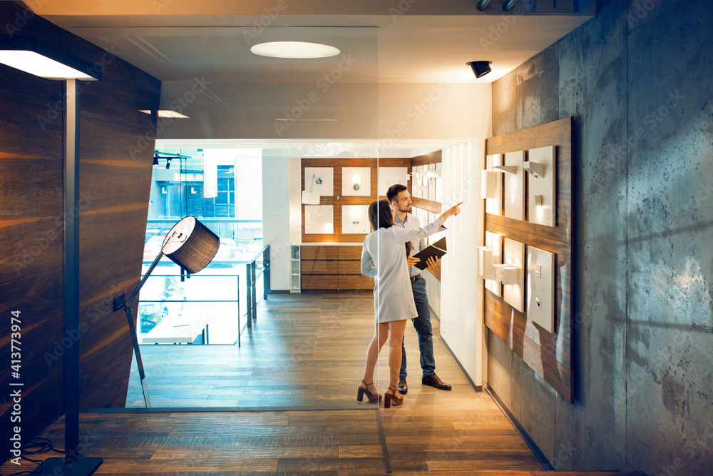 Businesswoman showing illuminated lamps to colleague in office Businesswoman showing illuminated lamps to colleague in office
