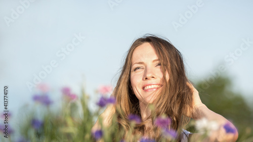 Beautiful woman with long hair over sky and flower background