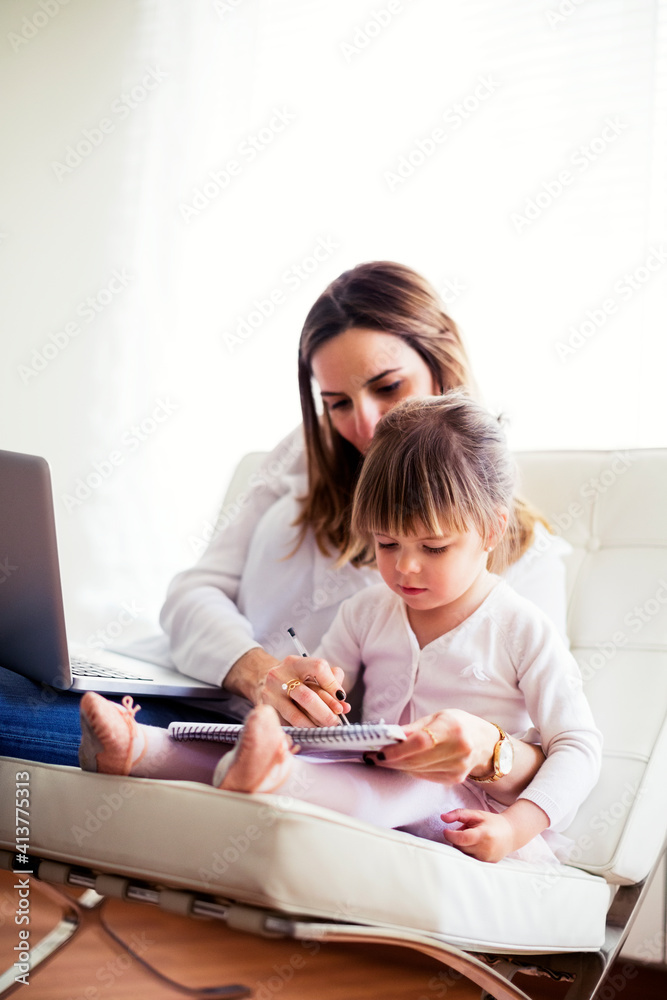 Mother assisting daughter in studying at home Mother assisting daughter in studying at home