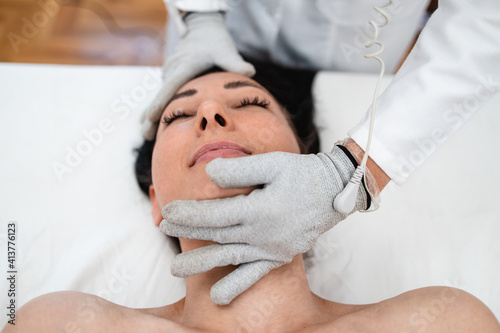 Micro sensory electrical BIO EMS micro-current treatment for face and body electrode stimulation with conductive gloves. Anti wrinkle and anti-aging lifting. Selective focus.