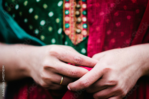 Midsection of woman in salwar kameez with hands clasped photo