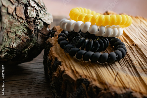 Fashionable and modern elastic hair springs. Different colors of stretching hand bracelets on wooden background, stand
