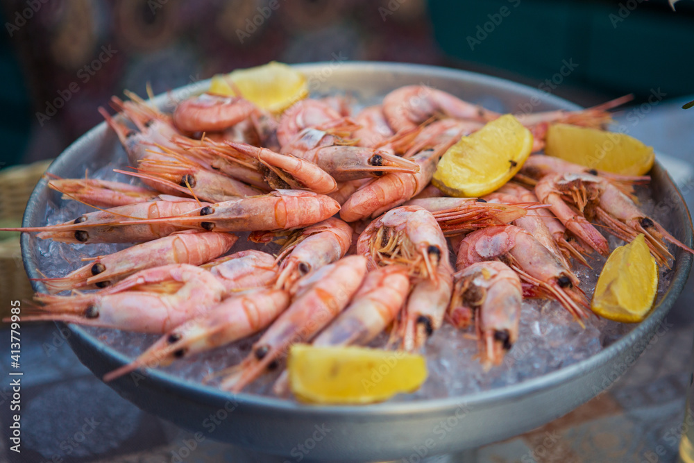 shrimp in ice with lemon on a table in a restaurant