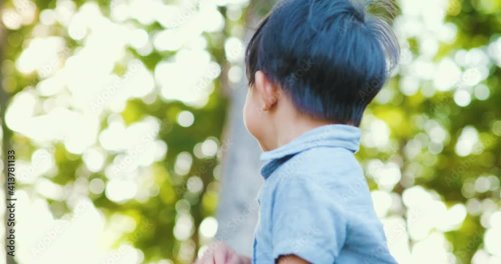 Little boy walking on green meadow grass morning sunrise happy children in outdoor nature park