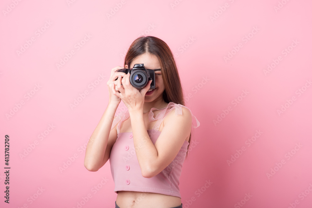 Asian woman tourist was running her to various places.happy excited emotional young woman photographer tourist standing isolated on ping background