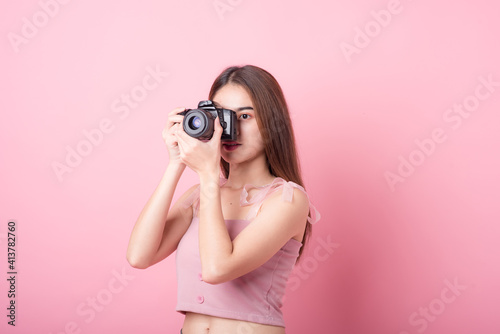 Asian woman tourist was running her to various places.happy excited emotional young woman photographer tourist standing isolated on ping background
