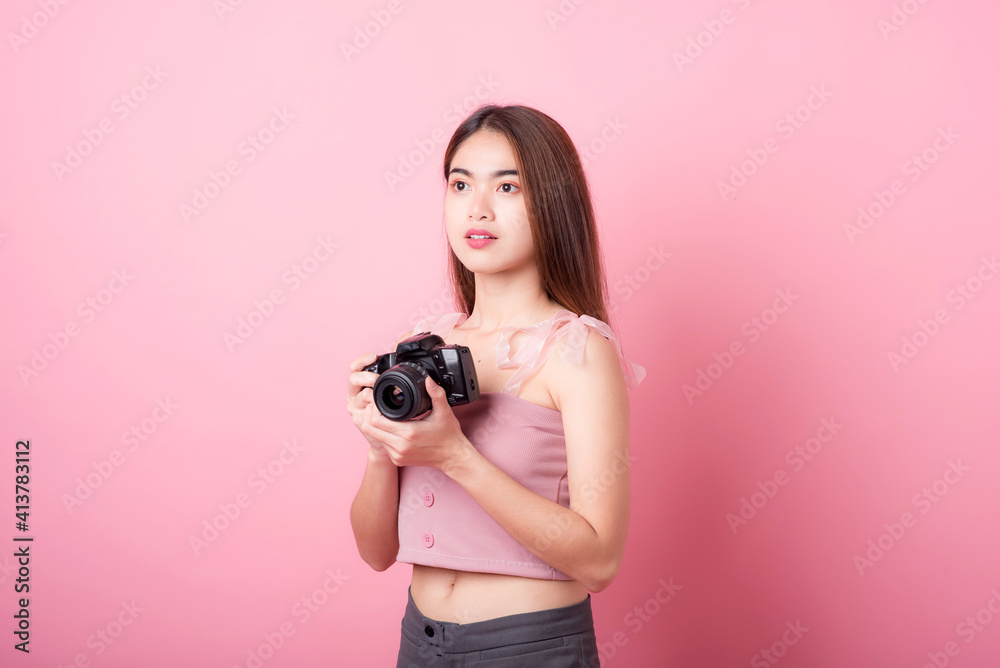 Asian woman tourist was running her to various places.happy excited emotional young woman photographer tourist standing isolated on ping background Asian woman tourist was running her to various places.happy excited emotional young woman photographer tourist standing isolated on ping background