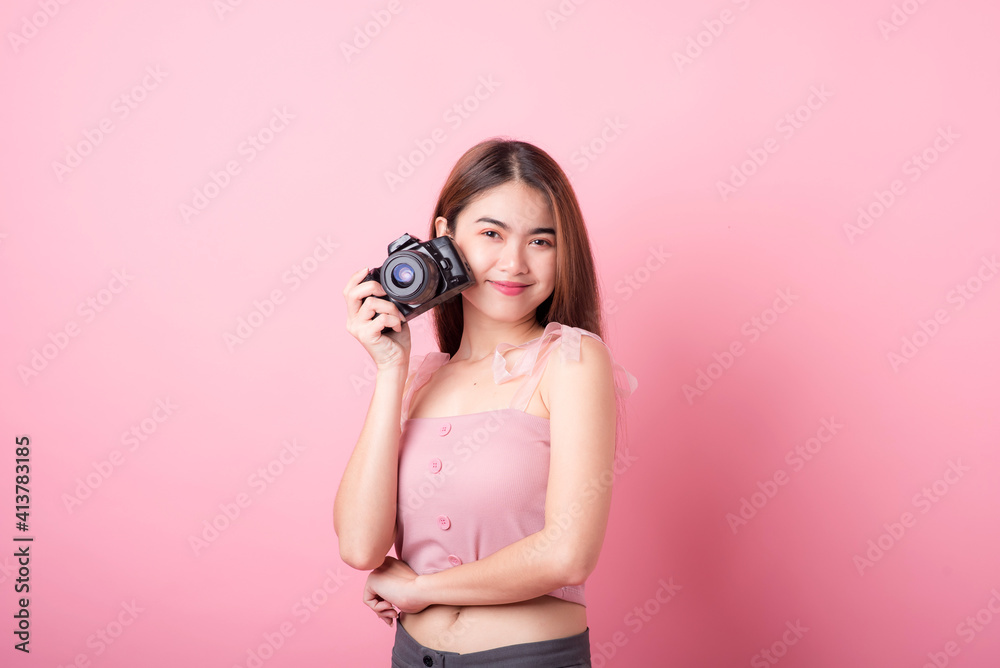 Asian woman tourist was running her to various places.happy excited emotional young woman photographer tourist standing isolated on ping background Asian woman tourist was running her to various places.happy excited emotional young woman photographer tourist standing isolated on ping background