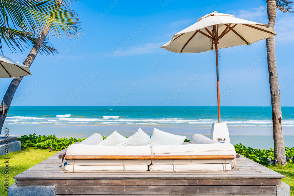 Obraz premium Umbrella and chair around sea beach ocean with coconut palm tree
