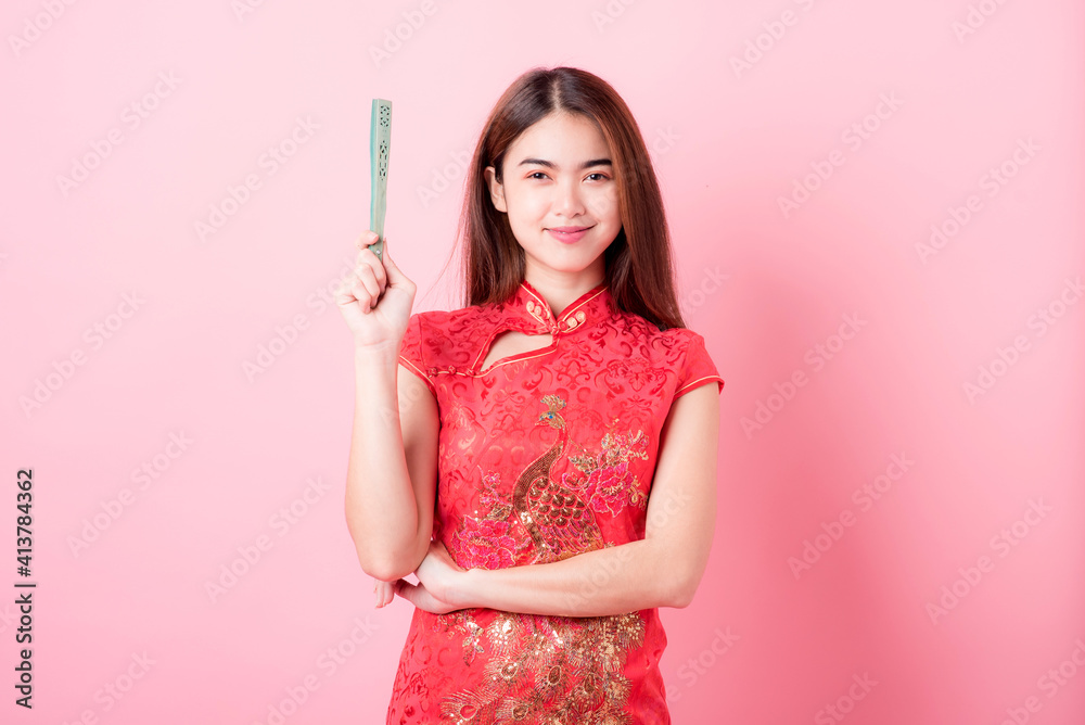 Action portrait beautiful Asian girl wearing Cheongsam red dress the celebration of something in a joyful and exuberant way. Festivities Chinese new year and Celebration concept Action portrait beautiful Asian girl wearing Cheongsam red dress the celebration of something in a joyful and exuberant way. Festivities Chinese new year and Celebration concept