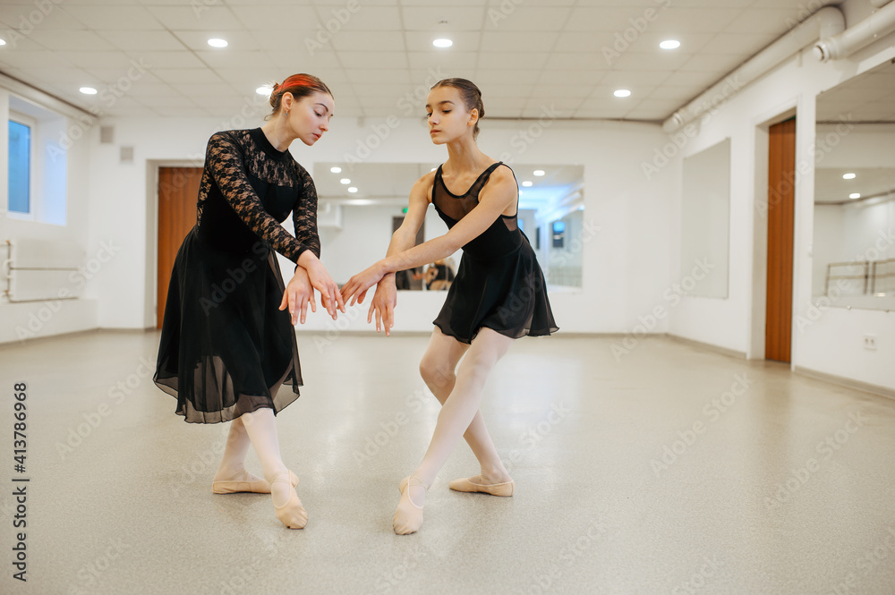 Fototapeta premium Teacher rehearsing with young ballerina in class