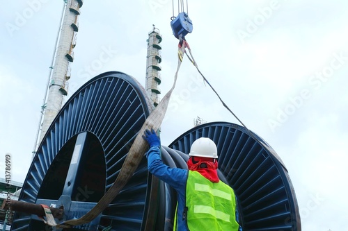 Billede på lærred Worker or rigger during high risk and put on safety helmet commencing crane, boo