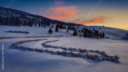 snowy landscape with snow barriers after sunset © Jaro
