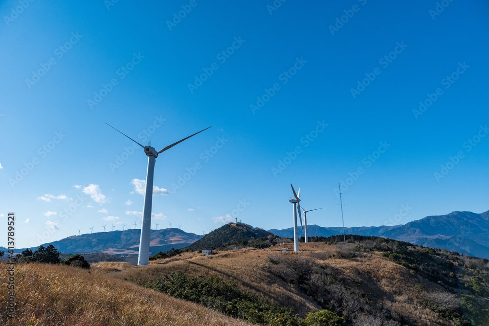再生エネルギーのイメージ　青空の下回転する風車　風力発電プラント