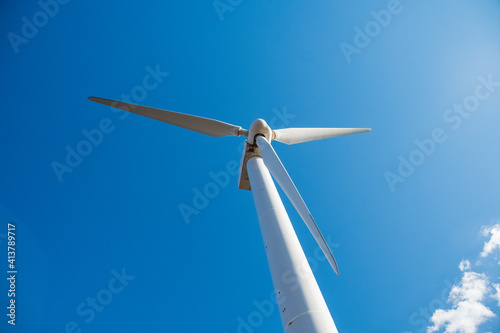再生エネルギーのイメージ　青空の下回転する風車　風力発電プラント