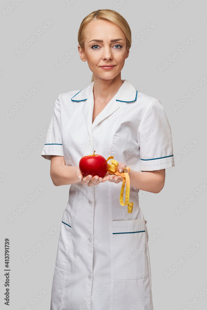 nutritionist doctor healthy lifestyle concept - holding organic red apple and measure tape