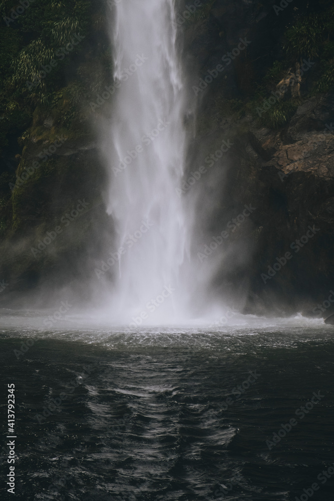 Powerful waterfall down the mountain into Milford Sound, New Zealand Powerful waterfall down the mountain into Milford Sound, New Zealand