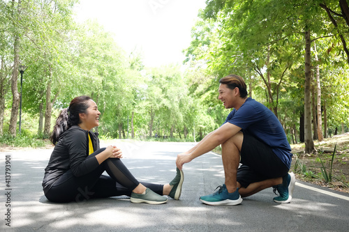 Bild auf Leinwand Asian young woman in sportwear is Cramping her leg and boyfriend helping for relaxation of resilient and Muscle contraction after excersice and running in the Garden