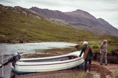 two women with boat in remote salmon fishing river through mountains photo