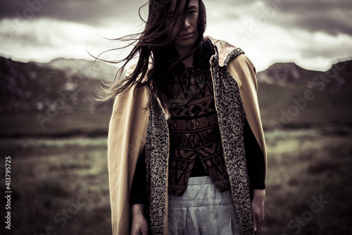 Dark moody portrait of wild woman in cloak
