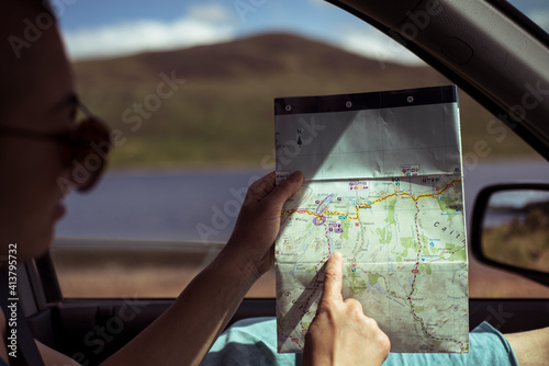Wallpaper Mural person on road trip in car points at old map Torontodigital.ca