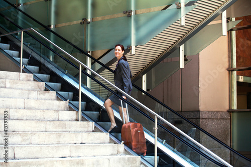 Wallpaper Mural Confident businesswoman standing with suitcase on escalator Torontodigital.ca