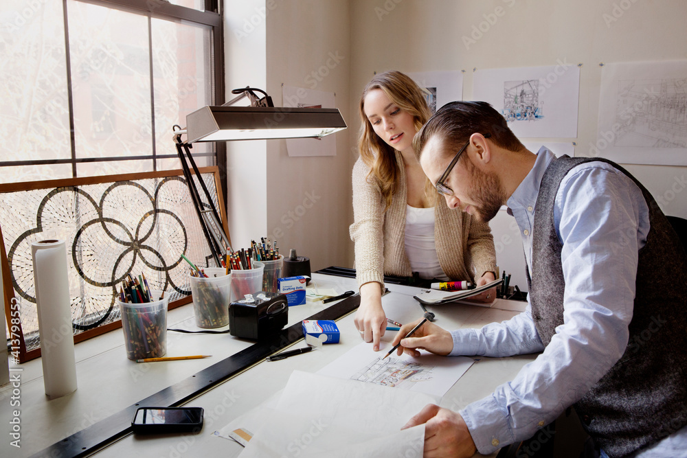 Colleagues working at table in art studio Colleagues working at table in art studio