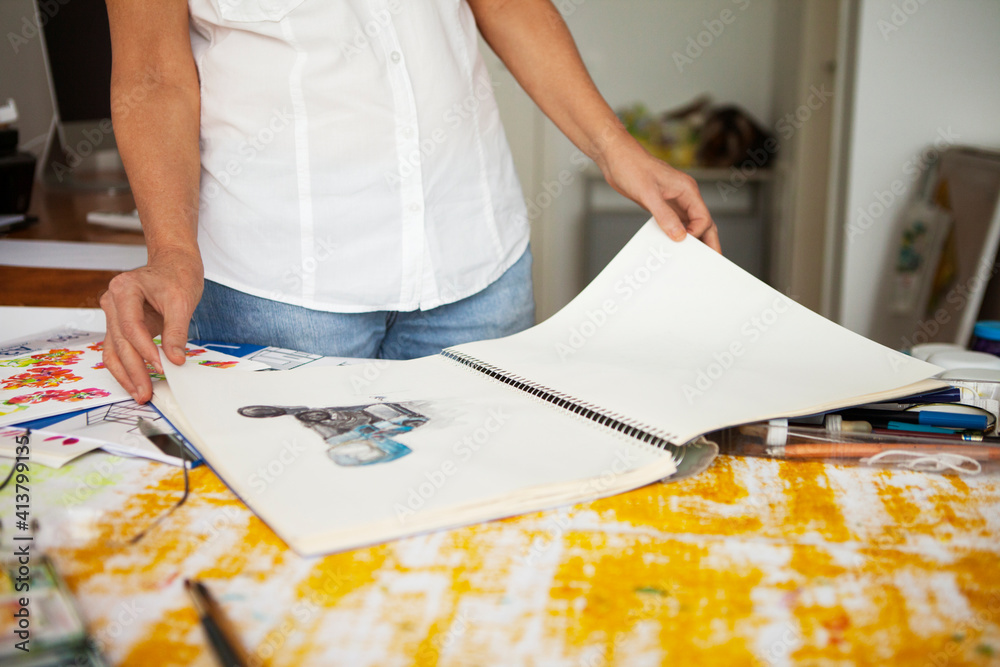 Cropped image of woman looking at sketches in art studio Cropped image of woman looking at sketches in art studio