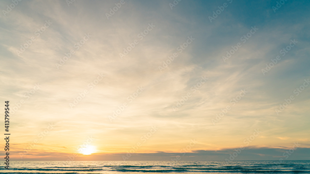 Sunset sky over sea in the evening with colorful orange sunlight, dusk sky background. 