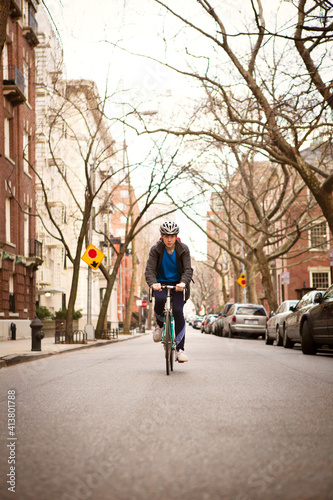 Wallpaper Mural Man cycling on road amidst buildings in city Torontodigital.ca