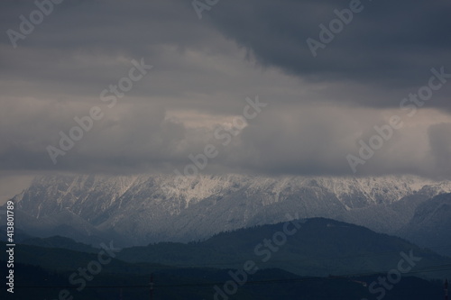 Fototapeta Naklejka Na Ścianę i Meble -  Snowy peaks hidden by clouds